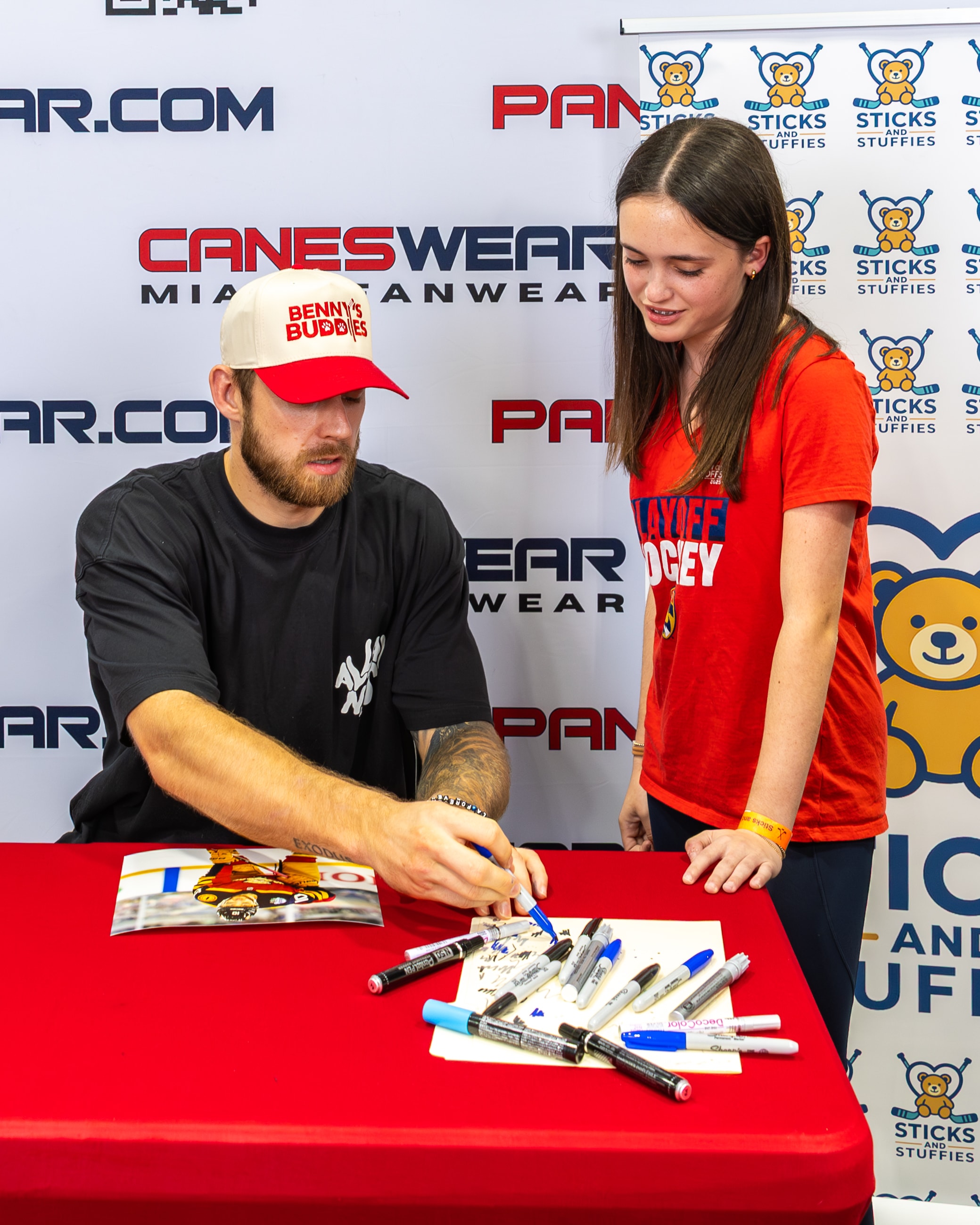A.J. Greer signing autographs at a table at the Sticks and Stuffies event at CanesWear